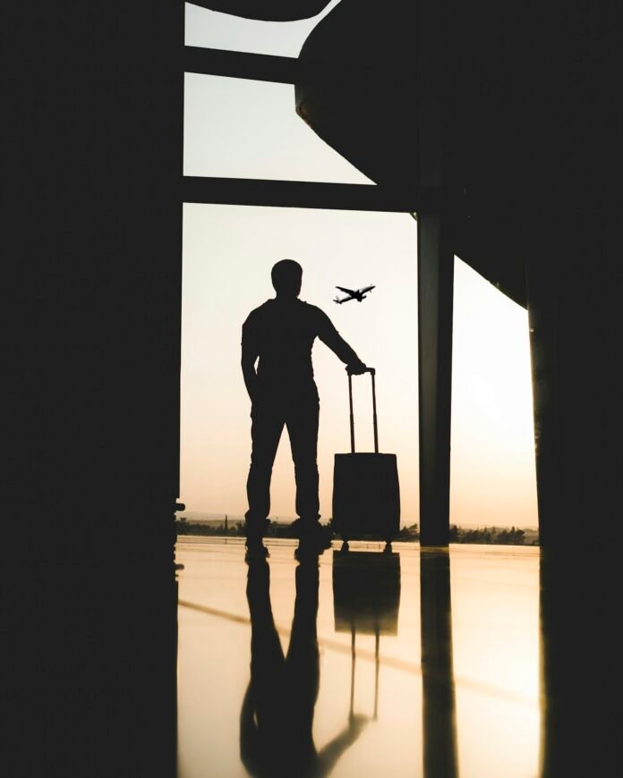 Person holding luggage inside an airport, representing relocating abroad (japa)