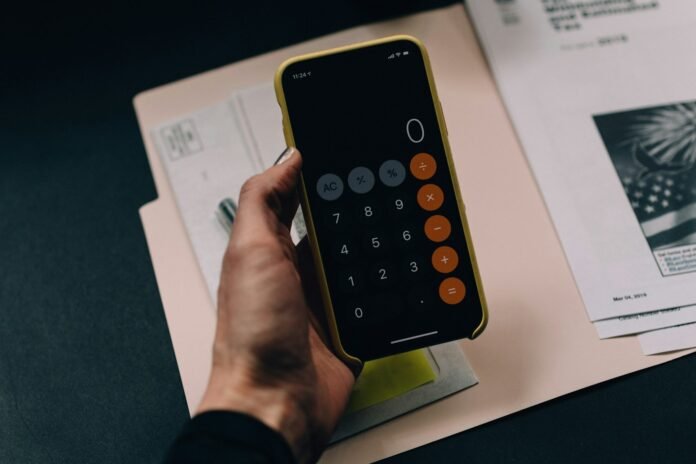 Person using a phone calculator to work out real salary after inflation