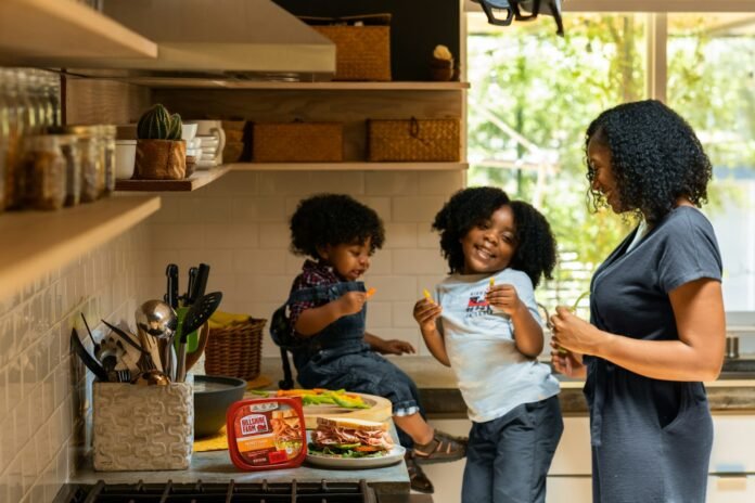 Mother and children preparing food together, representing family food budgeting in Nigeria