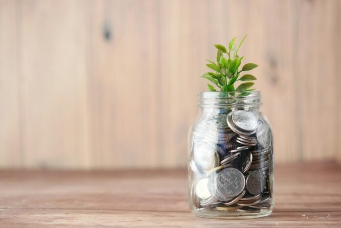 Glass savings jar filled with coins, representing building an emergency fund