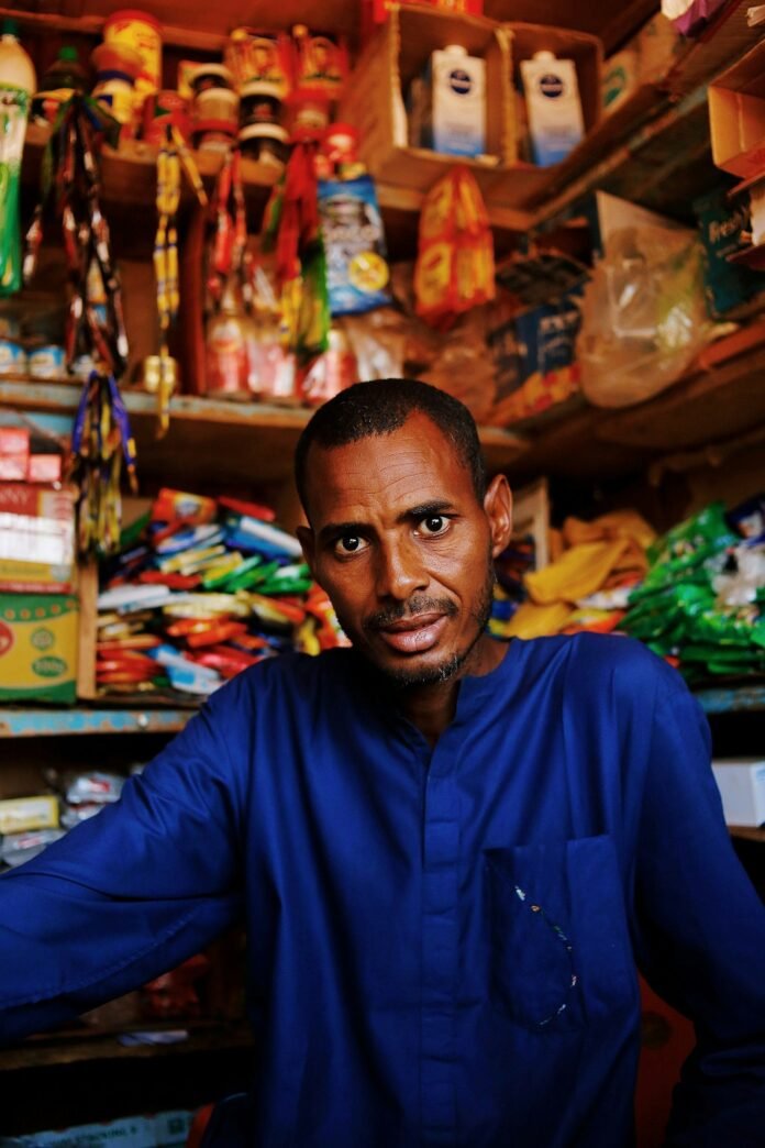 Nigerian small business owner in his shop, illustrating how inflation and energy costs affect SMEs