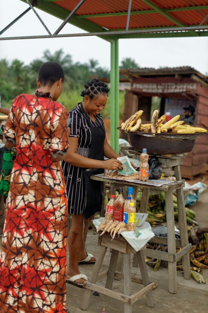 Women buying food at a Nigerian market, illustrating why prices still feel high even as inflation eases